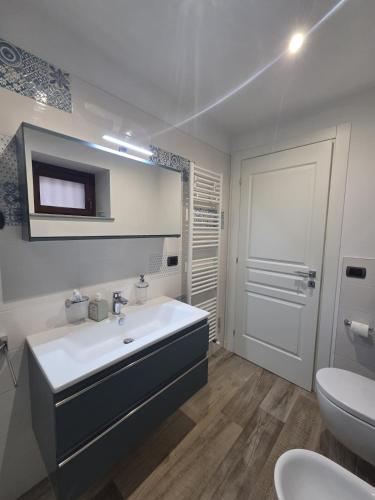a white bathroom with a sink and a toilet at Mirtillo & Margot in Cambiano