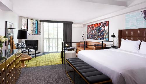 ein Schlafzimmer mit einem großen weißen Bett und einem Schreibtisch in der Unterkunft Montrose at Beverly Hills in Los Angeles