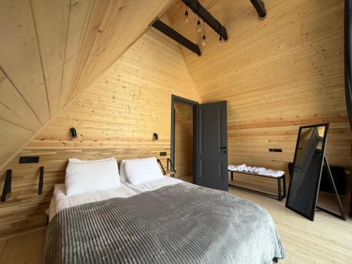 een slaapkamer met een groot bed in een houten kamer bij Kazbegi Story in Kazbegi