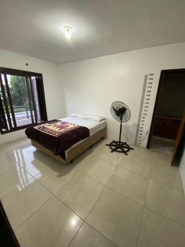a bedroom with a bed and a chair in a room at Casa para Pernoite no Centro de Osório in Osório