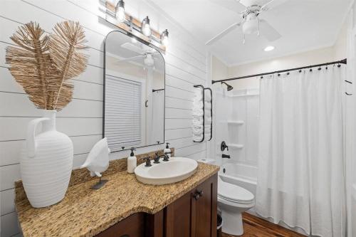 a bathroom with a sink and a toilet and a vase at Grandy 30A in Inlet Beach