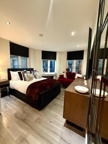 a bedroom with a large bed and a living room at Cozy Studio Flat in Bradford City Centre in Bradford