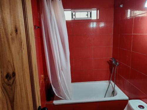 a red bathroom with a bath tub and a shower curtain at Cabañas Mirador de Maitencillo 2 in Maitencillo
