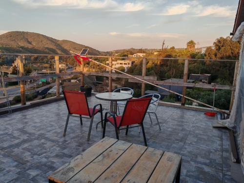 een terras met een tafel en stoelen op een dak bij Cabañas Mirador de Maitencillo 2 in Maitencillo
