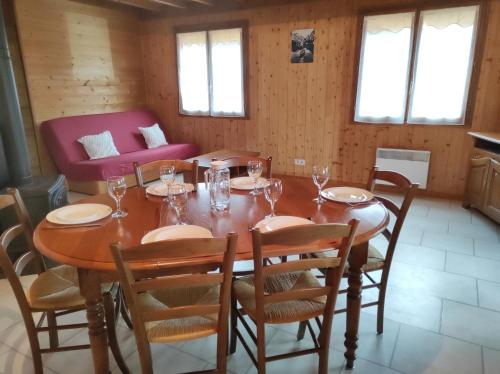 une salle à manger avec une table, des chaises et un canapé dans l'établissement Location d'un chalet de vacances, à Pont-de-Poitte