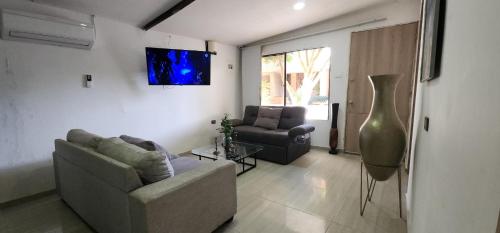 een woonkamer met een bank en een stoel bij Casa campestre plata cerca in Puerto Colombia
