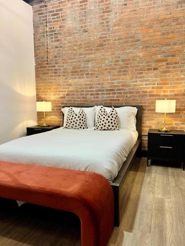 a bedroom with a large bed with a brick wall at Brick & Bed Riverfront Lofts, T 302 in Saint Louis