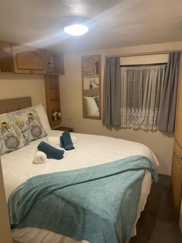 a bedroom with a large bed with two blue pillows at Skye Holiday Caravan 6 in Uig