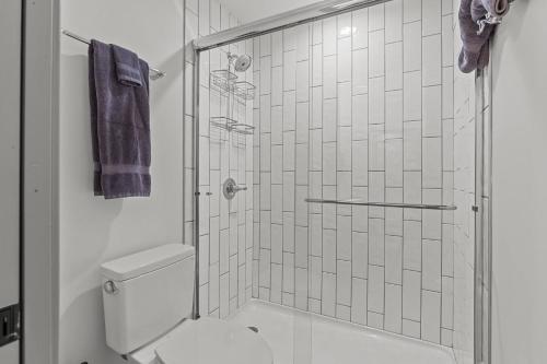 a bathroom with a toilet and a glass shower at Brick & Bed Riverfront Lofts, T 302 in Saint Louis