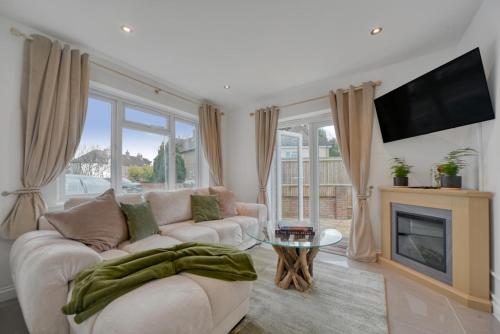 a living room with a couch and a fireplace at The Friendly Fern Apartment in Bickley