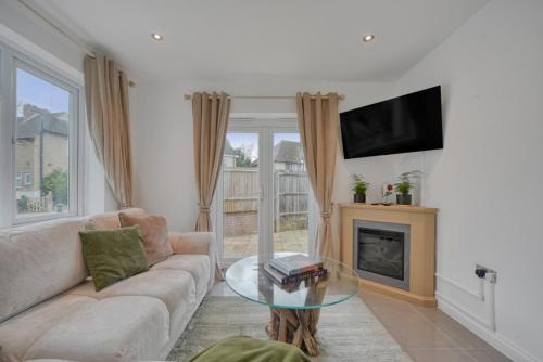a living room with a couch and a fireplace at The Friendly Fern Apartment in Bickley