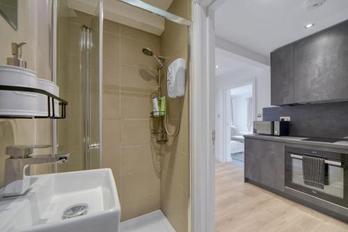 a bathroom with a shower and a sink in a room at The Friendly Fern Apartment in Bickley