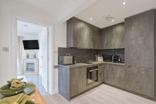 a kitchen with stainless steel cabinets and a table at The Friendly Fern Apartment in Bickley