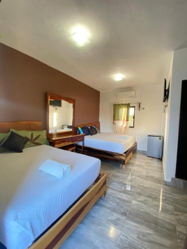 a hotel room with two beds and a television at Jungla maya hotel in Bacalar