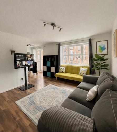 een woonkamer met een bank en een gele bank bij Crown Heights Executive Apartment in Manchester