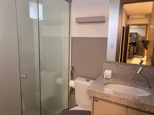 a bathroom with a toilet and a sink and a shower at Aptos em Prédio com Piscina e Academia - GRL in Anápolis