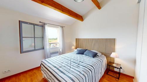 a bedroom with a bed with blue pillows and a window at Villa BlueGreen in Coëx