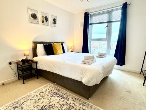 a bedroom with a large bed with a window at VIPAbodes at The Nankeville Woking in Woking