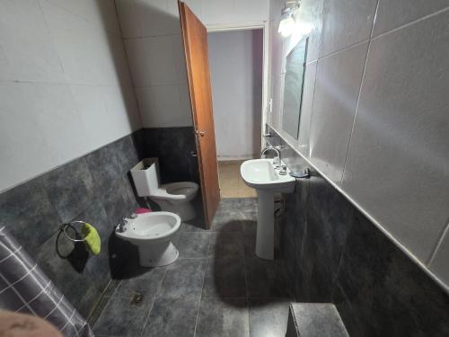 a small bathroom with a toilet and a sink at La fragata estadias in San José