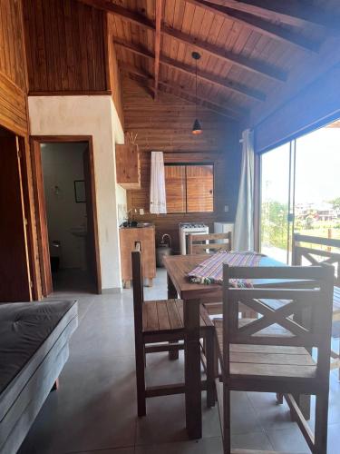 een eetkamer met een houten tafel en stoelen bij Residencial Bambu in Garopaba