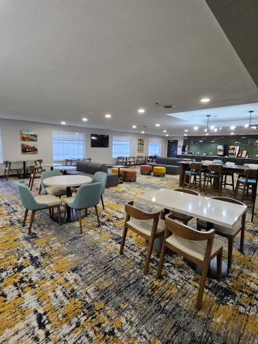 a large room with tables and chairs and a couch at La Quinta Inn & Suites by Wyndham Minot in Minot