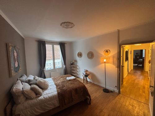 een slaapkamer met een bed en een lamp erin bij Gîte du Palais 3 étoiles in Châteauneuf-sur-Cher