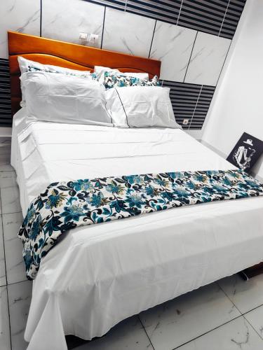 two beds with white sheets and a floral bedspread at Résidence meuble in Abidjan