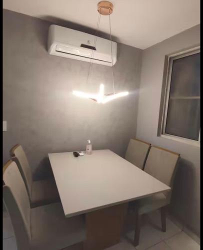 una sala da pranzo con tavolo e sedie bianchi di Ótima localização 20 min Pajucara a Maceió