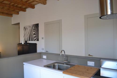 Una cocina con gabinetes blancos y un fregadero. en Porta 22 Charme&Relax, en Bérgamo