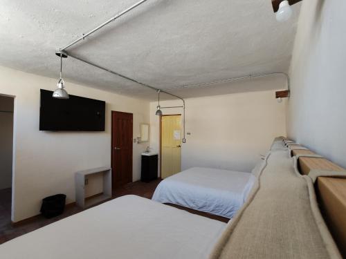 En eller flere senge i et værelse på Hostalgia