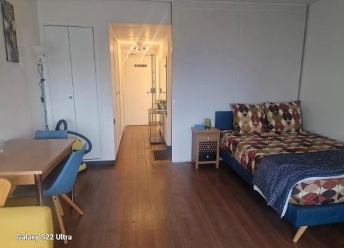 una camera da letto con un letto e un tavolo e una sala da pranzo di Vue Panoramique a Puteaux