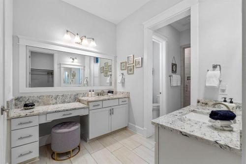 a white bathroom with two sinks and a mirror at Sunset Key in Inlet Beach