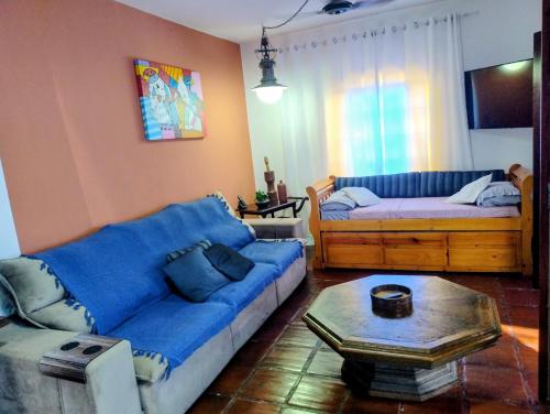 een woonkamer met een blauwe bank en een tafel bij Casa Cantinho no Litoral in São Sebastião