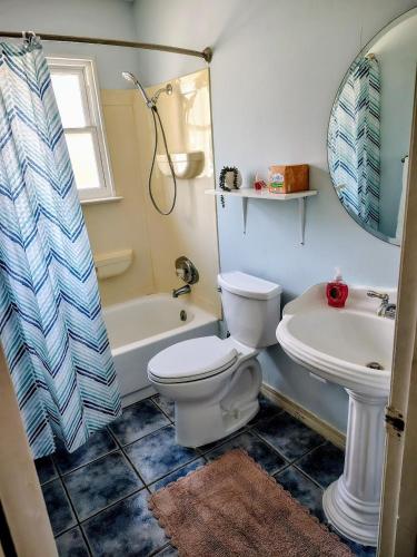 a bathroom with a toilet and a tub and a sink at Seagull`s Rest in Navarre