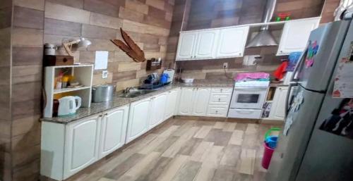 eine Küche mit weißen Schränken und einem Kühlschrank in der Unterkunft Hosteria TDT in Mar del Plata