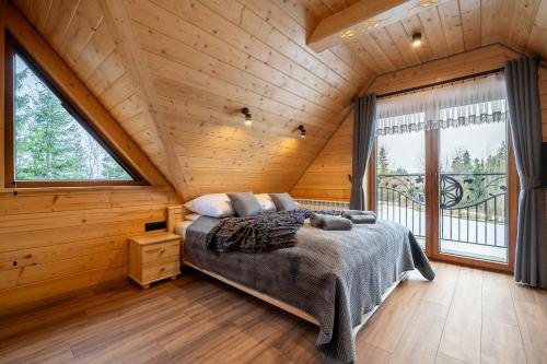a bedroom with a bed in a wooden cabin at Drewniane Zacisze in Biały Dunajec
