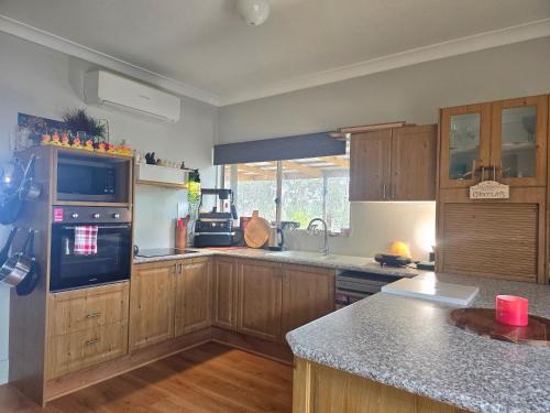 eine Küche mit Holzschränken und einer Arbeitsplatte in der Unterkunft Blue Horizon, Couple's GC Hinterland retreat in Tallebudgera