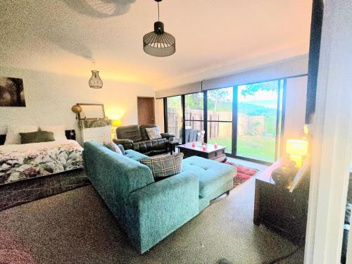 ein Wohnzimmer mit Sofa und Bett in der Unterkunft Blue Horizon, Couple's GC Hinterland retreat in Tallebudgera