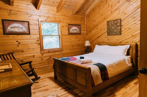 a bedroom with a bed in a log cabin at Creekside Oasis! in Stanton
