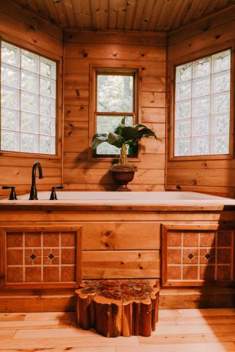 a bathroom with a tub in a wooden cabin at Creekside Oasis! in Stanton
