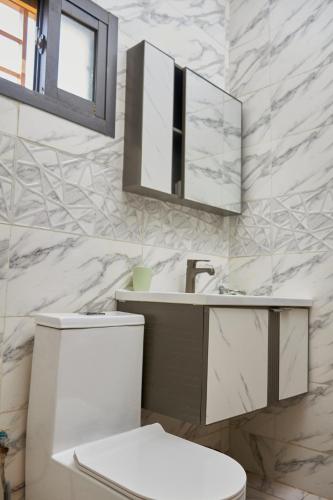 ein Badezimmer mit weißer Toilette und Waschbecken in der Unterkunft Résidences Riverside Abidjan in Abidjan