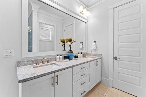 a white bathroom with a sink and a mirror at It's a Shore Thing in Inlet Beach