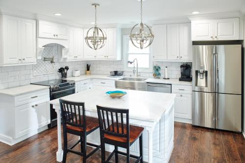 a kitchen with white cabinets and a table with chairs at Updated 2bed 2bath perfect for golfers, business travelers, and families in Greensboro