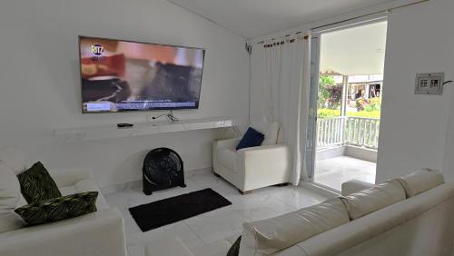 een woonkamer met een bank en een flatscreen-tv bij Hotel Terraza Girardot in Girardot