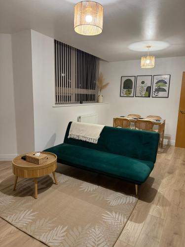 een woonkamer met een groene bank en een tafel bij Modern Refurbished Apt in Stevenage Town Centre in Stevenage