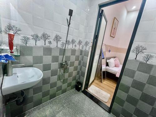 ein Bad mit einer Dusche, einem Waschbecken und einem Bett in der Unterkunft Naomi House Phan Thiet in Phan Thiet