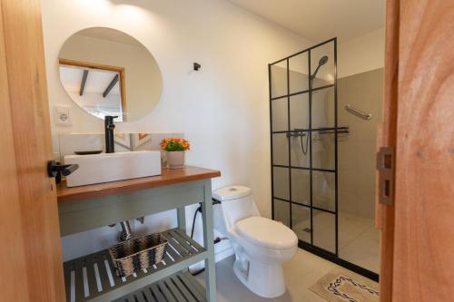 a bathroom with a toilet and a sink and a mirror at Orion in Punta Del Diablo