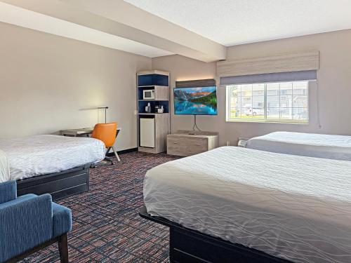 een hotelkamer met twee bedden en een flatscreen-tv bij Reston Inn & Suites in Spencer