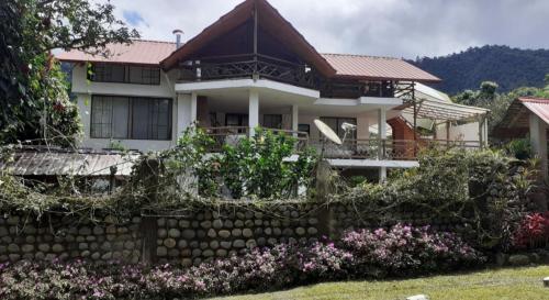 a house with a retaining wall and flowers at Mindo Suites in Mindo
