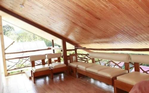 a room with chairs and a wooden ceiling at Mindo Suites in Mindo